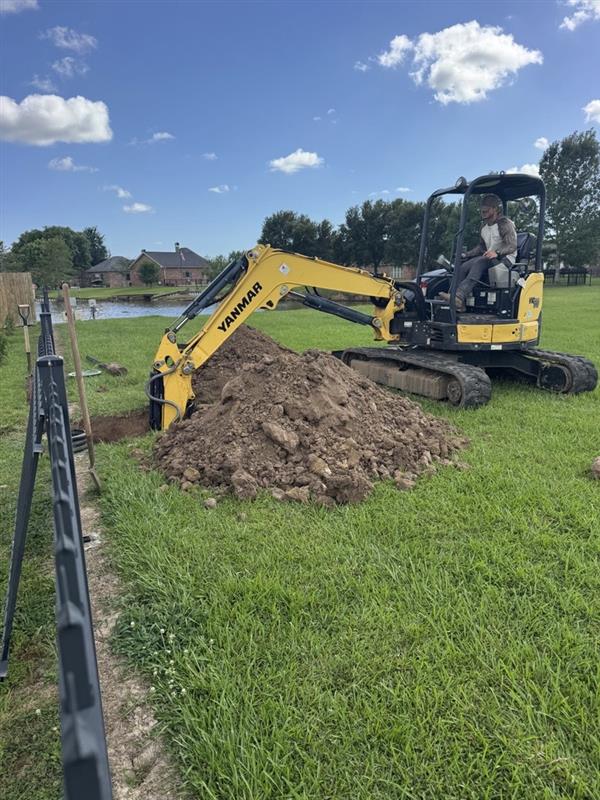 Gator excavator on a property beside a fence